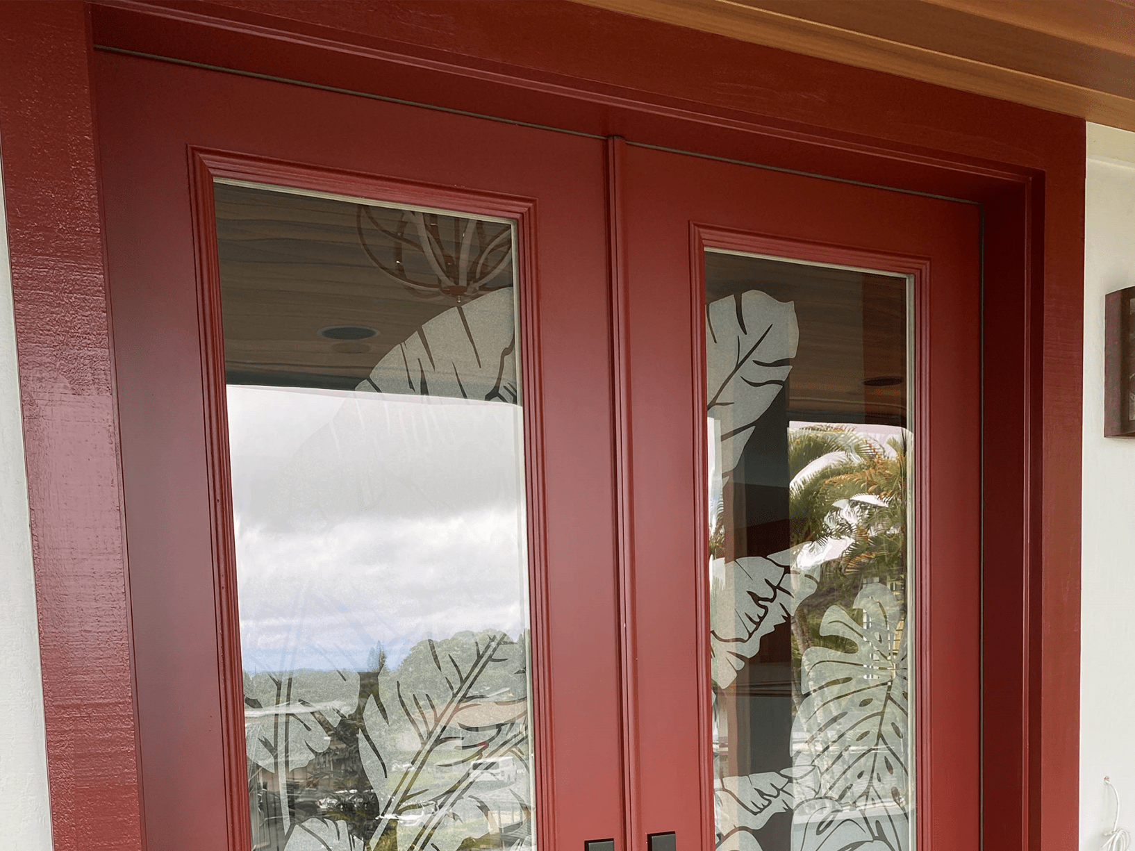 A Red Double Door Featuring An Intricate Leaf Design, Showcasing Elegance And Charm In Its Craftsmanship.